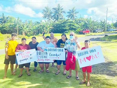 Families with signs welcoming their loved ones home