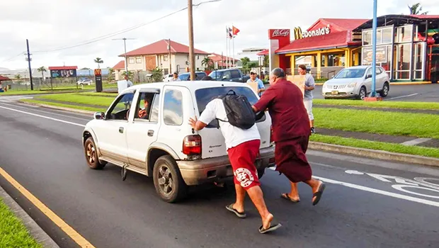 American Samoa Lieutenant Governor Lemanu pushing stalled car out of the way of traffic