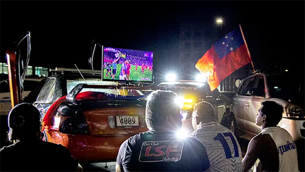 Car club, Leai Sou Feau members watch game on a big screen TV in front of the Government building. 