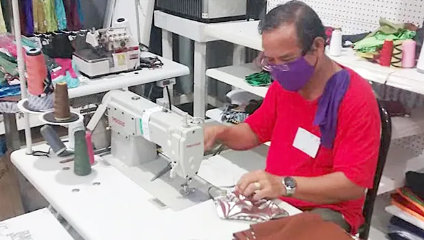 A worker at Manu'a Store sewing protective face masks