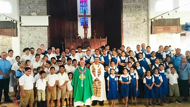 Most Reverend Bishop Peter Hugh Brown (front, center) who is pictured with St. Theresa Elementary School chaplain, Reverend Father Kolio Etuale; St. Theresa Elementary School principal Victor Langkilde (far left), staff members and students.