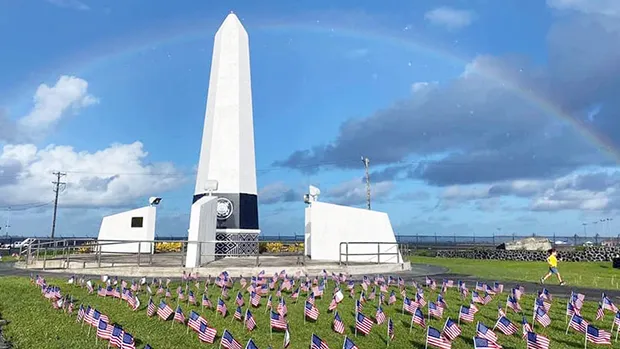 Small American Flags in front of Veterans Memorial Monument with rainbow overhead