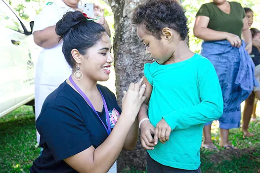 Fonoifafo Seumanu administering am MMR shot to a child