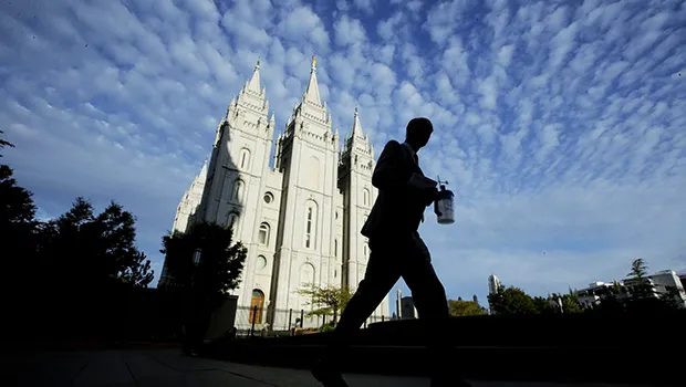 In this Sept. 14, 2016, file photo, a man walks past the Salt Lake Temple, a temple of The Church of Jesus Christ of Latter-day Saints, at Temple Square