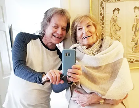 Leland Stein, left, takes a photo with his mother Sondra Green