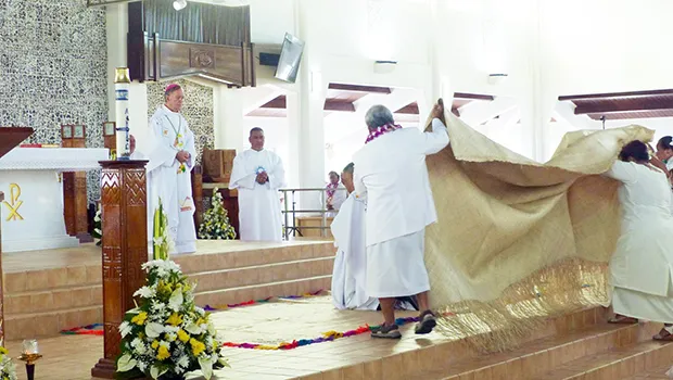 Bishop-elect Kolio Tumanuwao Etuale (kneeling as he is covered by a fine mat)