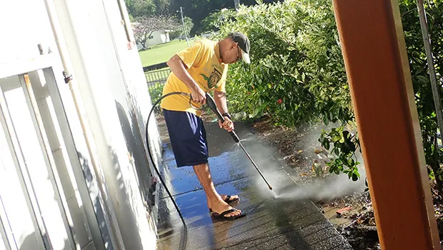 Niulaititi Hopkinson power washing the area outside of the Fatuoaiga Montessori School