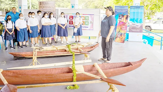 Chiildren viewing two newly carved paopao