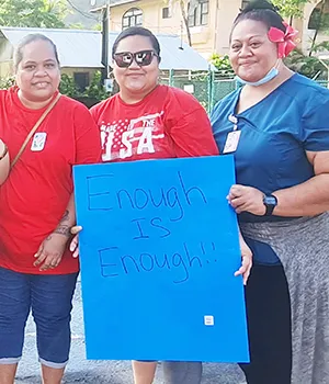 Three nurses with sign