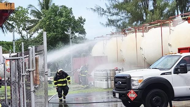 Firemen spraying water on storage tanks