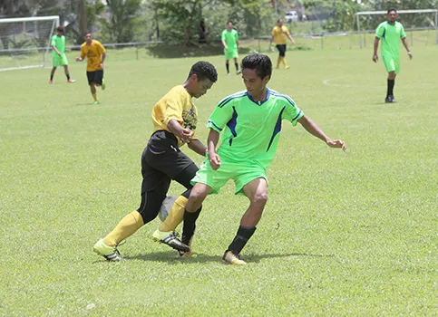 A Pago Youth players tries to dribble away from a Taputimu player