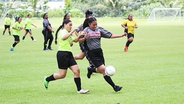 A Pago Youth player challenges a Taputimu Youth defender
