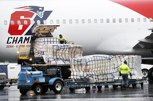 Palettes of N95 respirator masks are off-loaded from the New England Patriots football team's plane