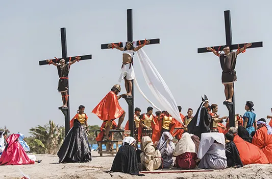 Ruben Enaje, center, dressed as Jesus, is seen nailed on cross 