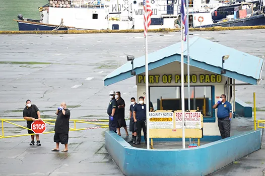 Port Administration and other ASG personnel at the entrance to the Port of Pago Pago stand guards with their masks, as security is tight at the dock due to a vessel in port with three confirmation COVID-19 cases. 