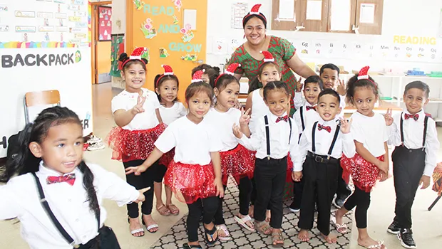 Room 4 students at Fatuoaiga Montessori School with their teacher all in Christmas finery