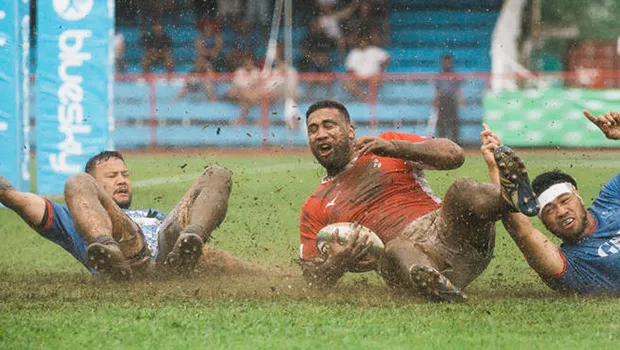 Cooper Vuna scores a try against Samoa on muddy field.