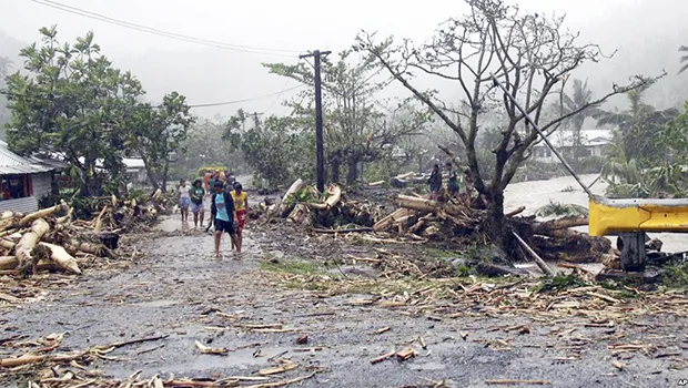 People walk through debris in Samoa's capital Apia, Dec. 14, 2012, after cyclone Evan