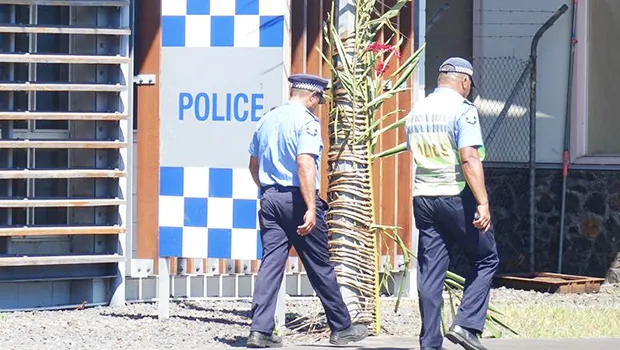 Two police officers walking out of police headquarters in Apia