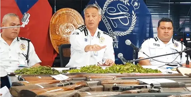 Samoa Police Commissioner along with two other officers in front of guns confiscated.