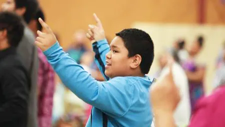 A young boy joins in singing praises to God at the Pacific Northwest Samoan Camp Meeting held at Sunset Lake Camp. Youth and adults alike participated in a training session on blending faith and culture