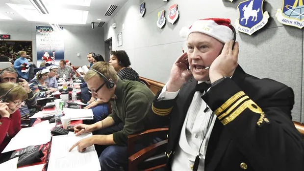 Canadian Lt. Maj. Chris Hache takes a call while volunteering at the NORAD Tracks Santa center 
