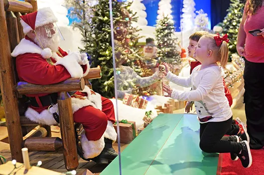 Julianna, 3, and Dylan, 5, visit with Santa through a transparent barrier