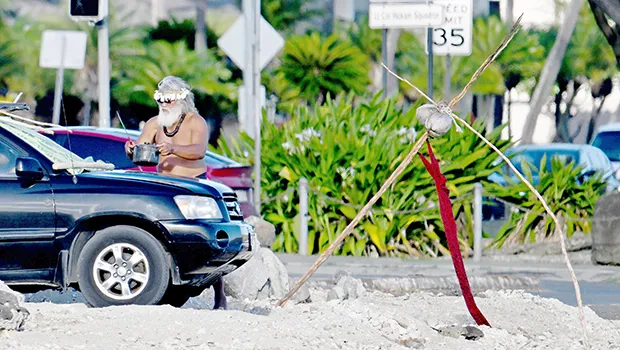 Saute Sapolu carrying a cooking pot