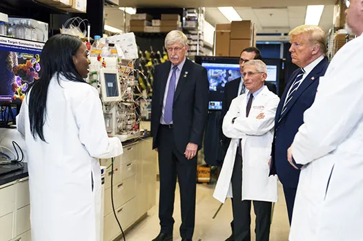 Dr. Kizzmekia Corbett, left, senior research fellow and scientific lead for coronavirus vaccines and immunopathogenesis team in the Viral Pathogenesis Laboratory, talks with President Donald Trump 