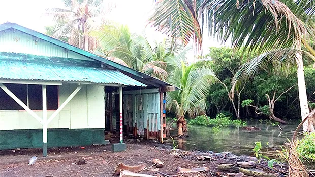 The tide can be seen coming dangerously close to a home in Nuuuli,