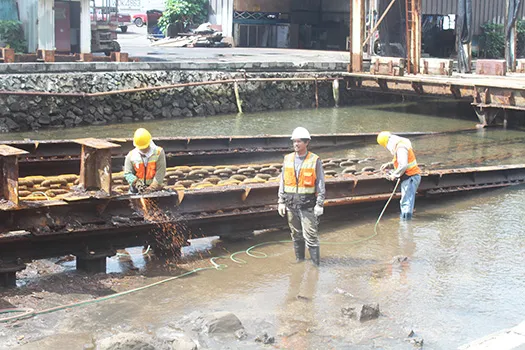 Three Ronald Reagan Shipyard employees, carrying out repair work
