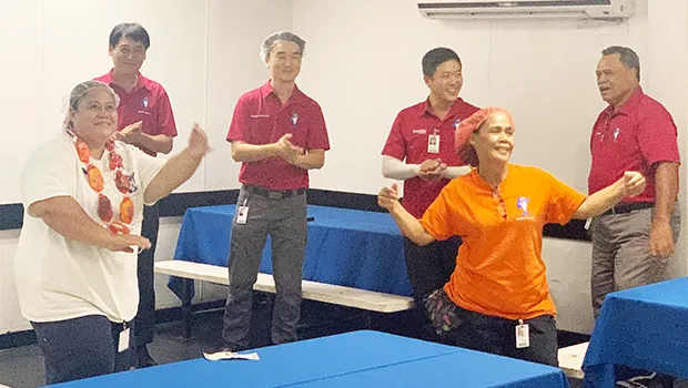 Members of the Starkist Samoa management team celebrate  Ms. Loretta Mika's years of service as she does the taualuga