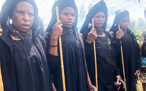 Highlands women dressed in long black robes attending a funeral 
