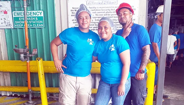 Three StarKist employees dressed in blue pose for the camera.