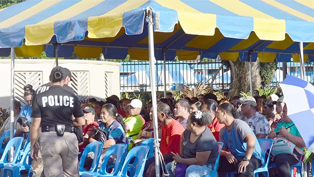 Crowds of people under tent waiting to cash stimulus checks