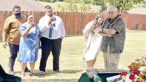Aaron Tui, his wife Catalina Salafai Markowitz Tui, Abraham Markowitz and Winnie Markowitz watch as their father, Barry Markowitz, shovel in hand, prepares to bury his wife, their mother.