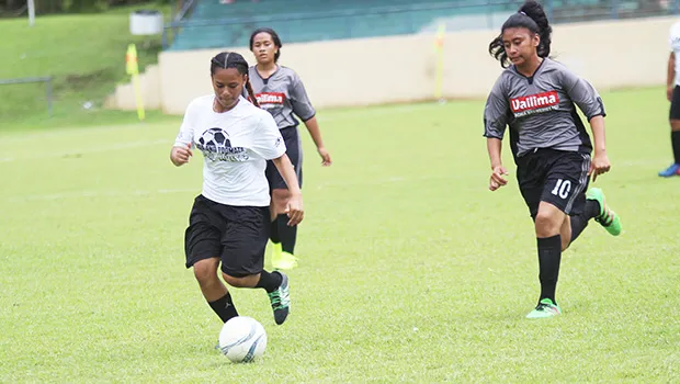 An Ilaoa & To’omata player dribbles away from a Taputimu Youth defender 