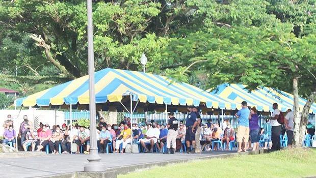 Crowds of people waiting under tents at TBAS to cash their stimulus checks