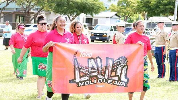 Teine Laulii Hawaii members marching with banner