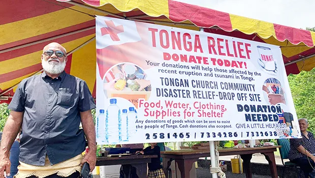 Paea Mateitalo Amelia in front of Tonga fundraiser banner