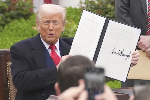 President Donald Trump holds a signed executive order