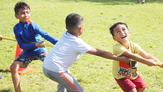Three youngsters really enjoying themselves during the tug-of-war 