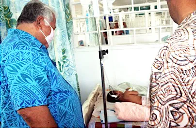 Prime Minister Tuilaepa Sailele Malielegaoi in a mask with sick child