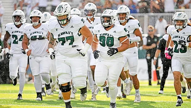 John Tuitupou with other UH Rainbow Warriors taking the field