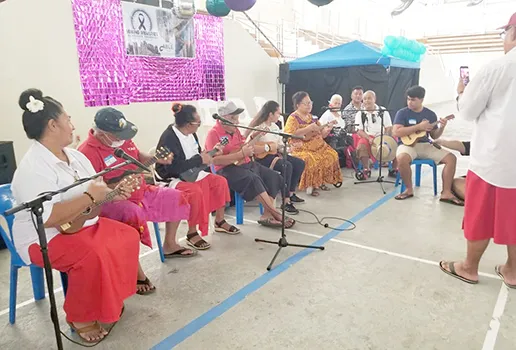 Senior citizens, students and others playing ukulele