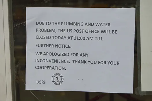 Photo of sign on door at USPS saying it would be closed TFN after plumbing problems discovered