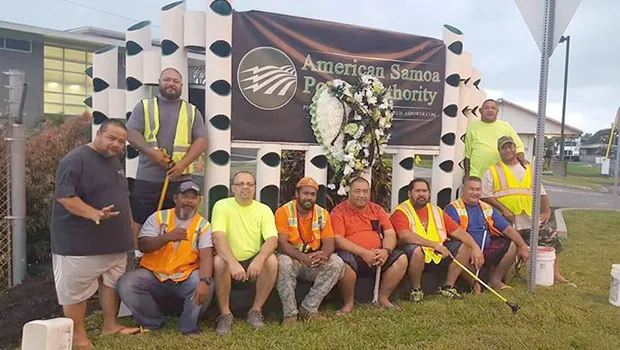 ASPA staff posing in front of wreath for Executive Director Utu at ASPA entrance 