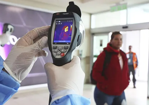 A Health Ministry staffer monitors the body temperature of travelers n Quito, Ecuador