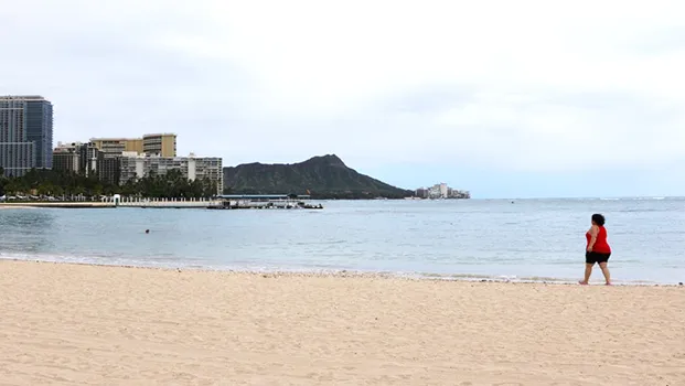 Lone woman walks on Waikiki beach