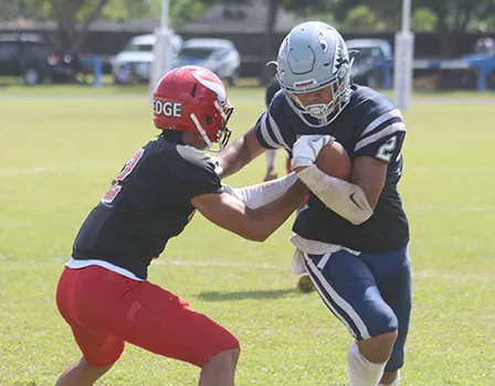 Samoana Sharks wide receiver Avery Seumanutafa trying to escape a tackle by Fitu Amata